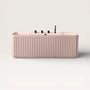 Front view of the Bellastone Kolpa back-to wall bath with black tap ware in pink