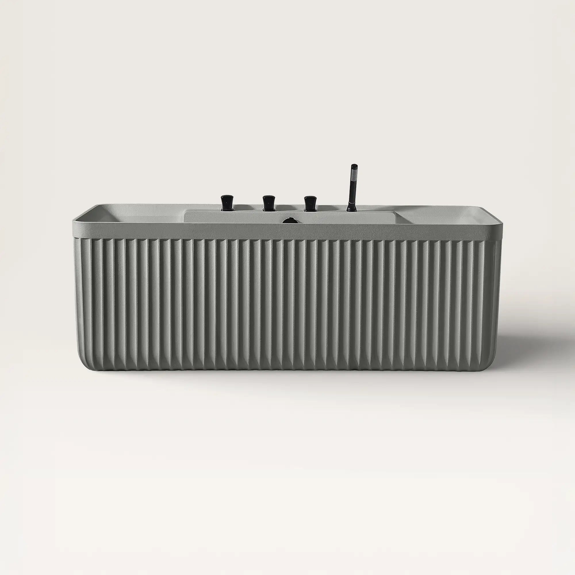 Front view of the Bellastone Kolpa back-to wall bath with black tap ware in cement grey