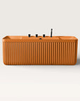 Front view of the Bellastone Kolpa back-to wall bath with black tap ware in orange