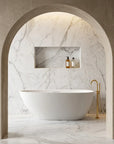 Modern bathroom with the Bellastone ARIA 1700mm freestanding bathtub in white, marble walls, and gold fixtures. 