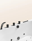 A top view of the Bellastone Doria spa bathtub in white with black tap ware, on a beige background